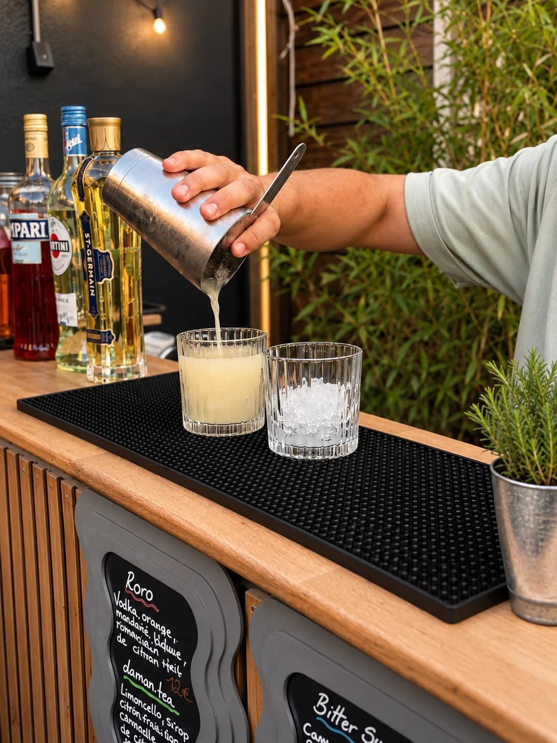 Barman du Hope versant un cocktail du shaker dans un verre, en gros plan