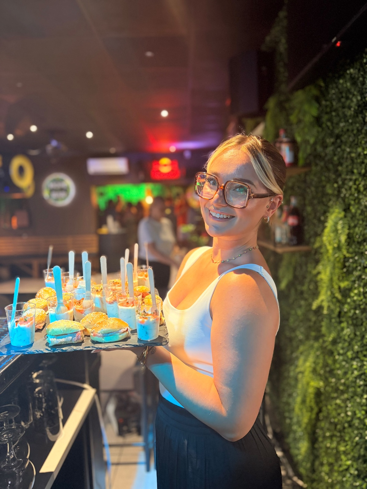 Ambiance soirée au Hope Bar avec mur végétal et néons