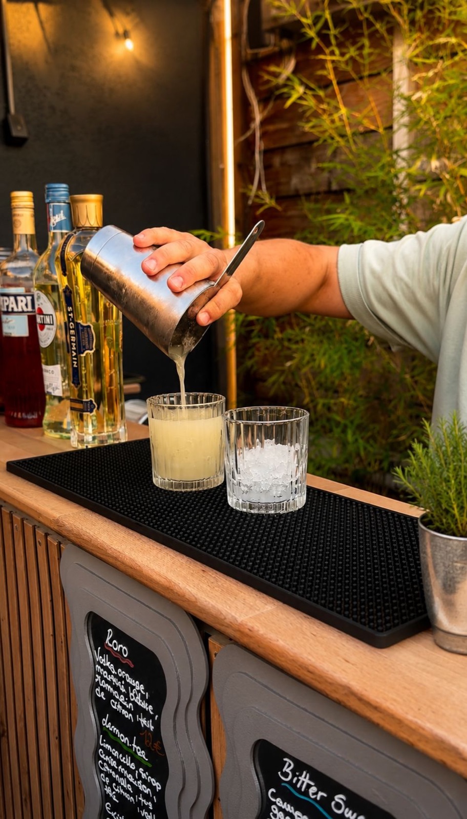 Bar mobile Hope : barman préparant un cocktail au shaker sur un bar en bois lors d'un événement
